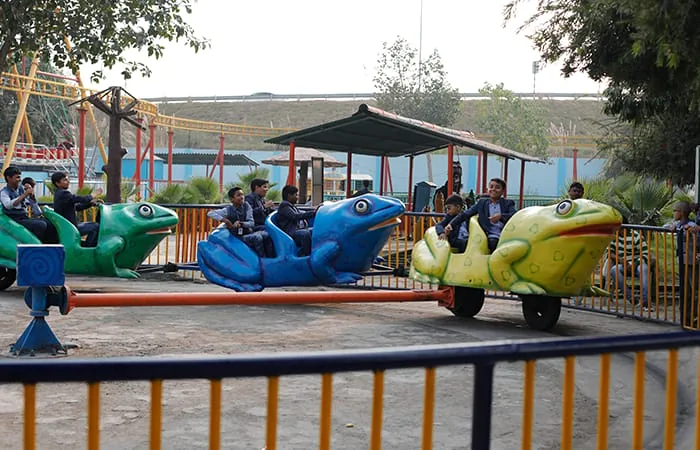 Children riding a frog-themed carousel at Club Platinum Resort