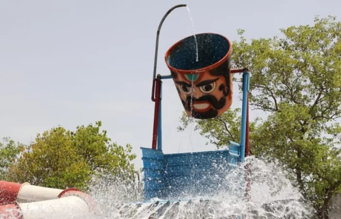Tipping-bucket splash structure with water slides behind at the Club Platinum Resort water park