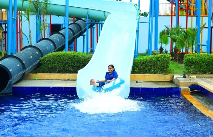 Visitor riding an inflatable ring down a water slide at Club Platinum Resort