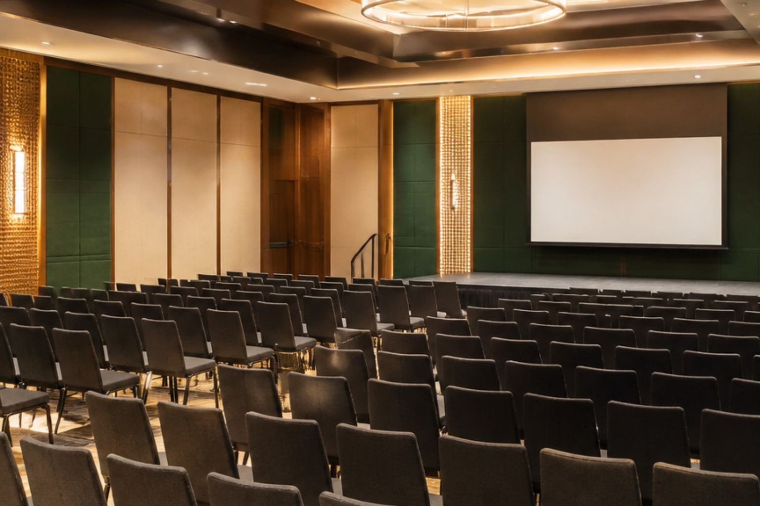 Conference hall in Gurgaon arranged theatre-style with a projector screen for a corporate conference