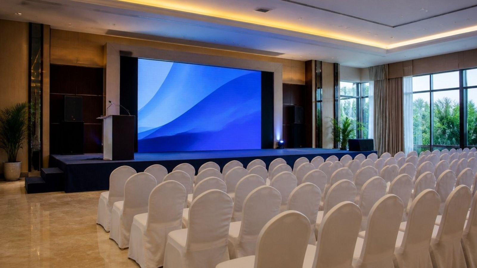 Dealers meet venue setup in Manesar with a stage, presentation screen and rows of guest seating