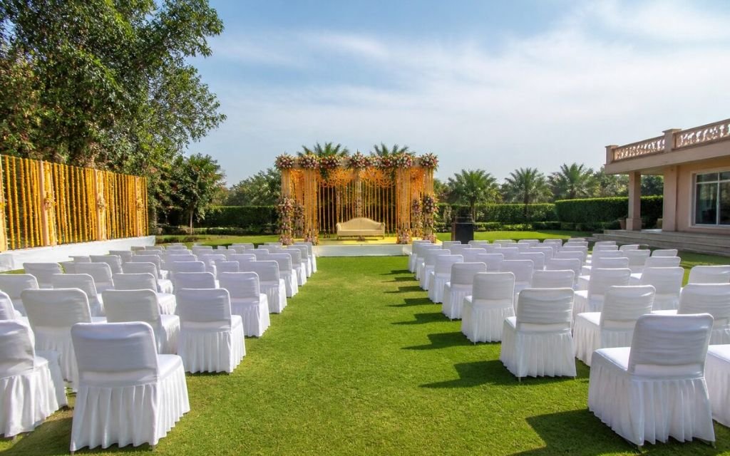 Open party lawn in Manesar with covered seating and a floral arch set up for an outdoor engagement celebration