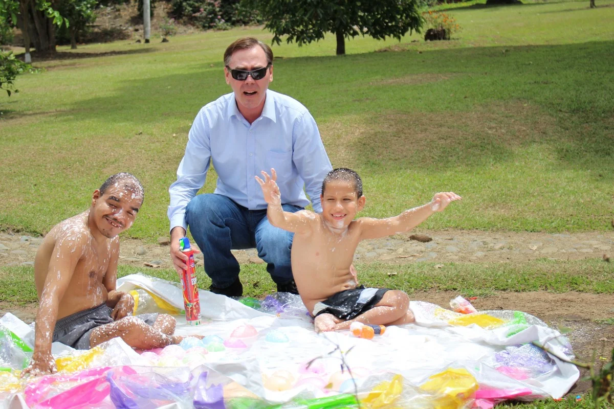Father and two children playing outdoors on a lawn — representative photograph of a family day out