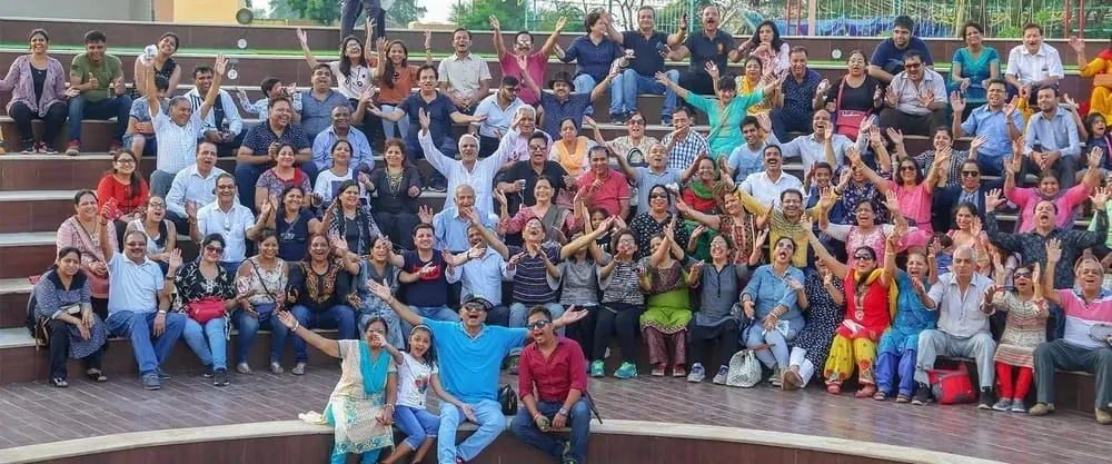 Large group enjoying a team outing in the open amphitheatre-style seating at Joygaon Picnic Park